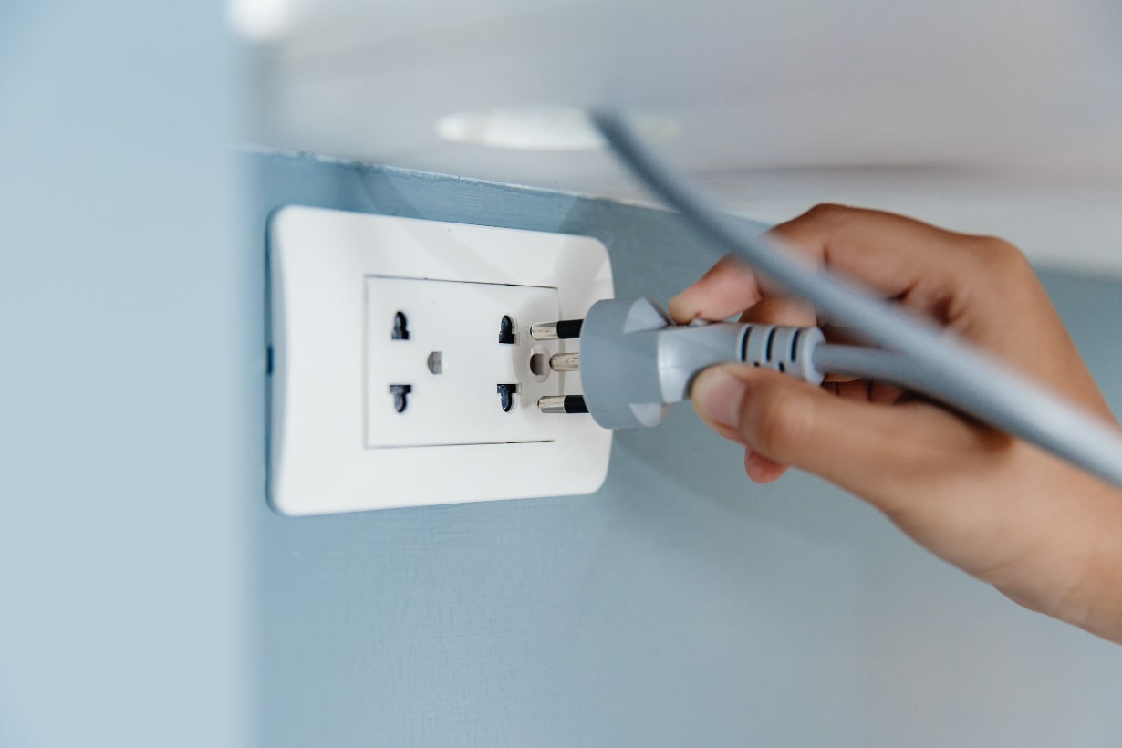 Closeup hand plug in wall socket electricity to power electric appliance Closeup hand plug in wall socket electricity to power electric appliance